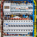 Switchboard equipment. Shield for enterprise electrification. Switchboard for control over electrical equipment. Labeled panel with wires and switches at enterprise.